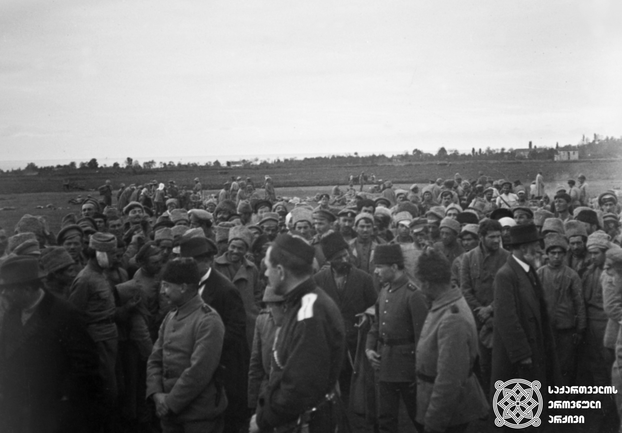 ამერიკავკასიის სეიმის წევრი, საქართველოს ეროვნული საბჭოს თავმჯდომარე  და ქართველ სოციალ-დემოკრატთა ლიდერი ნოე ჟორდანია ქართველ ჯარისკაცებთან ერთად ნატანებში, ოსმალურ არმიასთან ჩოლოქის ბრძოლის შემდეგ. <br>
1918 წლის 7-8 აპრილი. <br>
Member of the Transcaucasian Sejm, chairperson of the National Council of Georgia and the leader of the Georgian Social-Democrats, Noe Zhordania together with the Georgian soldiers in Natanebi, after the battle of Choloki against the Turkish forces. <br>
7-8 April, 1918.